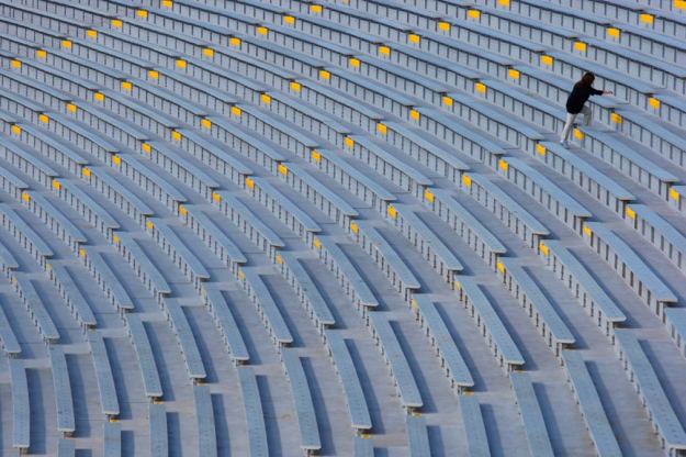 A stadium worker makes her way through the stands a couple hours before kickoff.